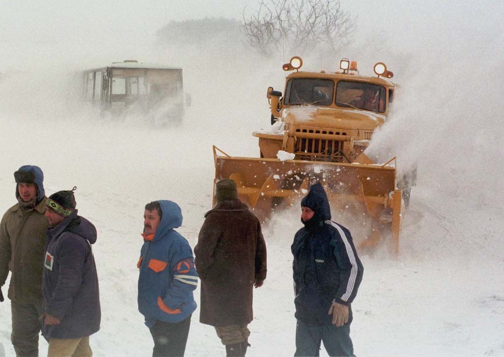 Na snímke snehová fréza premiestnená až z Nitry uvoľňuje 24 hodín zafúkaný autobus na ceste z Košíc do Jasova.